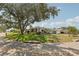 Street view of single-story home with lush front yard, mature trees, and well-kept landscaping at 3966 High Bluff Dr, Largo, FL 33770