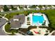 An aerial view showcasing the community pool, lounge chairs, clubhouse, and playground at 4023 Wild Senna Blvd, Tampa, FL 33619