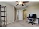 Bedroom with carpet, ceiling fan, desk and shelving units, and doors to bathroom and hallway at 4023 Wild Senna Blvd, Tampa, FL 33619