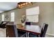 Well-lit dining room with a wooden table, upholstered chairs, overhead lighting, and large windows at 4023 Wild Senna Blvd, Tampa, FL 33619
