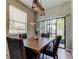 Dining room with a wooden table, four upholstered chairs, an overhead light fixture, and sliding doors at 4023 Wild Senna Blvd, Tampa, FL 33619