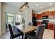 The dining room is adjacent to the kitchen and features a wooden table, four upholstered chairs, and sliding doors at 4023 Wild Senna Blvd, Tampa, FL 33619