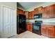 Well-lit kitchen with black appliances, granite countertops, tile flooring, and wooden cabinets at 4023 Wild Senna Blvd, Tampa, FL 33619