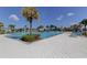 Community pool with palm trees, sun loungers, and splash pad at 4023 Wild Senna Blvd, Tampa, FL 33619