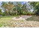 Picturesque backyard scene with mature trees, brick firepit area, and brick patio at 4205 N Suwanee Ave, Tampa, FL 33603