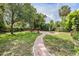 Beautifully landscaped backyard with brick path leading to brick firepit seating area at 4205 N Suwanee Ave, Tampa, FL 33603