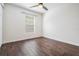 Bright bedroom featuring dark wood-look tile flooring, ceiling fan and a window with blinds at 4205 N Suwanee Ave, Tampa, FL 33603