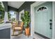 Inviting front porch with rocking chairs, potted plant and stylish door of the gray, two-story home at 4205 N Suwanee Ave, Tampa, FL 33603