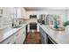 Modern kitchen featuring stainless steel appliances, white cabinets and tiled backsplash with an island at 4205 N Suwanee Ave, Tampa, FL 33603