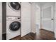 Hallway laundry area shows stackable washer and dryer along with wood-look flooring at 4205 N Suwanee Ave, Tampa, FL 33603