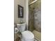 Bathroom featuring a toilet, enclosed shower, tiled backsplash, and decorative wall art at 4239 Woodland Retreat Blvd, New Port Richey, FL 34655