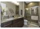 Bathroom features dual sinks, granite counters, modern fixtures and tiled walk-in shower at 4239 Woodland Retreat Blvd, New Port Richey, FL 34655