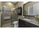 Bathroom with tiled shower, granite countertop, vanity, toilet, and framed mirror at 4239 Woodland Retreat Blvd, New Port Richey, FL 34655