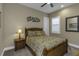 Comfortable bedroom features a wooden bed frame with tropical bedding, ceiling fan, and plantation shutters at 4239 Woodland Retreat Blvd, New Port Richey, FL 34655