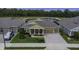 Beautiful home with a brick driveway, lush landscaping, and a charming covered porch at 4239 Woodland Retreat Blvd, New Port Richey, FL 34655