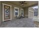 Covered porch with chairs, stone pillars, and a decorative front door at 4239 Woodland Retreat Blvd, New Port Richey, FL 34655