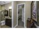 Hallway view to bathroom showing a vanity, water closet, shower, and view into the main bedroom at 4239 Woodland Retreat Blvd, New Port Richey, FL 34655