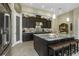 Modern kitchen features dark cabinets, granite countertops, stainless steel appliances, and large central island with barstool seating at 4239 Woodland Retreat Blvd, New Port Richey, FL 34655