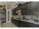 This kitchen features dark cabinets, stone backsplash, stainless steel appliances, and granite countertops at 4239 Woodland Retreat Blvd, New Port Richey, FL 34655