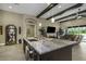 Open kitchen with large marble island bar and modern fixtures flows into spacious living area with beamed ceiling at 4239 Woodland Retreat Blvd, New Port Richey, FL 34655