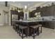 Beautiful kitchen boasts dark wood cabinets, stainless steel appliances, a large island with seating, and stone countertops at 4239 Woodland Retreat Blvd, New Port Richey, FL 34655