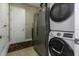 Laundry room features a washer, dryer, fridge and tile flooring at 4239 Woodland Retreat Blvd, New Port Richey, FL 34655