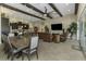 Open-concept living space with exposed beams, a dining area, modern kitchen, and seamless access to outdoor living at 4239 Woodland Retreat Blvd, New Port Richey, FL 34655