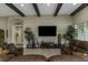 Living room with beamed ceiling, stylish decor, and comfortable leather seating for relaxing and entertaining at 4239 Woodland Retreat Blvd, New Port Richey, FL 34655