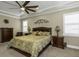 Comfortable main bedroom with a ceiling fan, neutral walls, and simple decor at 4239 Woodland Retreat Blvd, New Port Richey, FL 34655