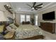 Elegant main bedroom boasting a tray ceiling, plush bedding, and ample natural light from shuttered windows at 4239 Woodland Retreat Blvd, New Port Richey, FL 34655