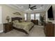 Serene main bedroom featuring a tray ceiling, a ceiling fan and plantation shutters at 4239 Woodland Retreat Blvd, New Port Richey, FL 34655