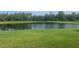 Calm pond reflecting the sky, bordered by a well-maintained lawn and mature trees at 4239 Woodland Retreat Blvd, New Port Richey, FL 34655