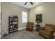 Sitting room with natural light, plantation shutters, bookshelves, and comfortable armchairs at 4239 Woodland Retreat Blvd, New Port Richey, FL 34655