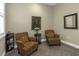 Inviting sitting area with armchairs, plantation shutters, and natural light at 4239 Woodland Retreat Blvd, New Port Richey, FL 34655