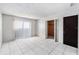 Bedroom showcasing neutral walls, tiled floor, closet, and sliding glass door at 4309 Cedar Grove St, Holiday, FL 34691