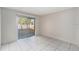 Bright bedroom with white tiled floors and a sliding glass door leading outside at 4309 Cedar Grove St, Holiday, FL 34691