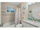 Bathroom featuring a shower and tub combination with tiled walls and decorative coastal accents at 5153 Bayley St, North Port, FL 34288