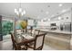 Well-lit dining area with a glass top table set adjacent to an open kitchen with an eat in island at 5153 Bayley St, North Port, FL 34288