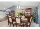Open dining room with wood table, chairs, china cabinet, and view to the living room and kitchen at 5153 Bayley St, North Port, FL 34288
