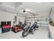 Bright garage with large door, motorcycle, lawnmower, and functional storage solutions at 5153 Bayley St, North Port, FL 34288