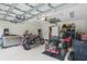 Spacious garage featuring a motorcycle, lawnmower, workbench and ample storage solutions at 5153 Bayley St, North Port, FL 34288