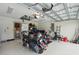 A well organized garage space with a motorcycle, lawn equipment, and storage racks at 5153 Bayley St, North Port, FL 34288
