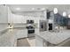 Bright, open kitchen features white cabinets, granite countertops, and stainless-steel appliances at 5153 Bayley St, North Port, FL 34288