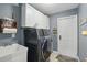 Laundry room with washer, dryer, sink, cabinets, and door at 5153 Bayley St, North Port, FL 34288