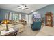 Comfortable living room with a sectional couch, ceiling fan, mounted TV, and blue walls offers a relaxing space at 5153 Bayley St, North Port, FL 34288