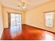 Cozy bedroom with a ceiling fan, hardwood floors, and sliding glass doors at 6213 Ashfield Pl, Wesley Chapel, FL 33545