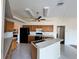 Traditional kitchen featuring wooden cabinets, black appliances, and a breakfast bar at 6213 Ashfield Pl, Wesley Chapel, FL 33545