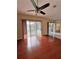 Bright living room with hardwood floors, ceiling fan, and sliding glass doors for natural light at 6213 Ashfield Pl, Wesley Chapel, FL 33545