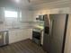 Modern kitchen featuring stainless steel appliances, granite countertops, and white cabinets at 639 48Th N Ave, St Petersburg, FL 33703