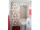 Bathroom featuring a shower/tub combo with orange floral curtain and decorative orange towels at 6508 Lenore Dr, Tampa, FL 33634